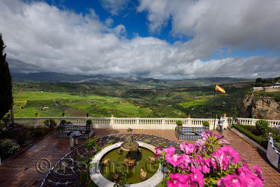 Garden patio overlook at Mondragon Palace with green fields and Serrania mountains Ronda Spain