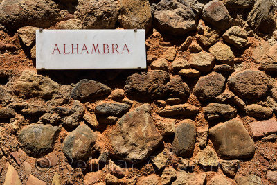 Sign for Alhambra at Gate of Justice on the ancient fortified wall of the hilltop fortress in Granada