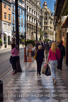 Pedestrians on the marble sidewalk of Catholic Kings street Granada Spain