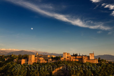 Blue sky and moon over hilltop Alhambra Palace fortress complex at sundown Granada