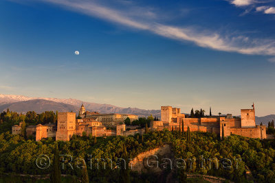Moon and golden sunset on hilltop Alhambra Palace fortress complex Granada