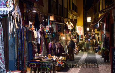Shops and tourists at night on Caldereria Nueva pedestrian street Granada