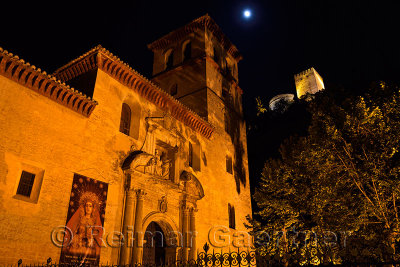 Church of Saint Peter and Paul at night with Alcazaba towers and moon in Granada