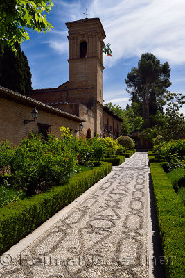 Stone patterned garden walkway of San Francisco convent with Bell Tower at Alhambra Palace Granada