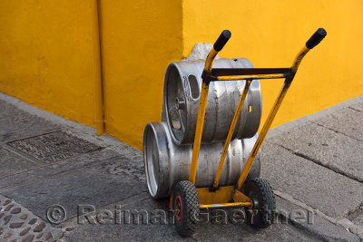 Yellow wall and dolly holding beer canisters in street of Cordoba Spain