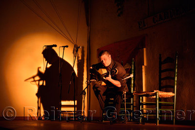 Solo Flamenco guitarist in spotlight on stage at night in Cordoba Spain