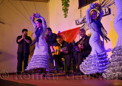 Spinning female Flamenco dancers on stage at night in an outdoor courtyard in Cordoba Spain