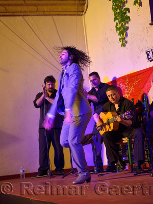 Male Flamenco dancer stomping on stage at night in an outdoor courtyard in Cordoba Spain