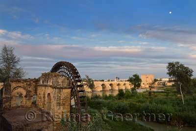 Moon at sundown over Guadalquivir River with Albolafia Waterwheel Roman Bridge and Calahorra Tower Cordoba