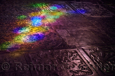 Stained glass colored light on carved tomb stone floor of Cordoba Cathedral Mosque