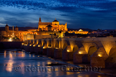 Night lights on Roman Bridge over the Guadalquivir River with Episcopal Palace and Cordoba Cathedral