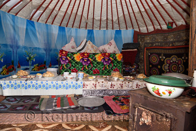 Interior of a yurt with stove and long table set for lunch guests
