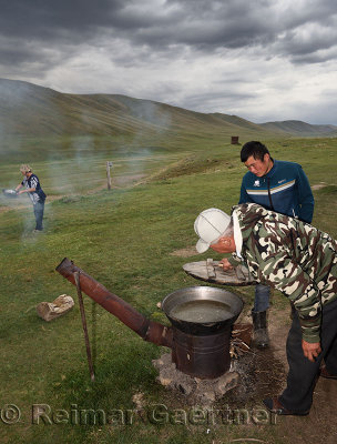 Kazakh family stewing meat on an outdoor oven on summer pasturelands of Assy Plateau Kazakhstan