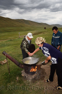 Kazakh husband and wife stirring lamb stew with noodles on Assy Plateau Kazakhstan