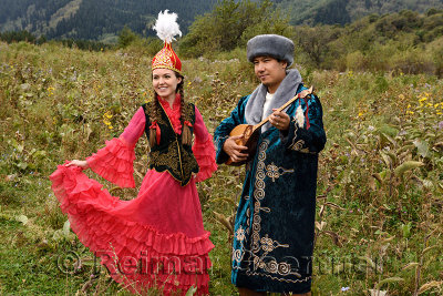 Young man and woman in traditional Kazakh cothing in a field at Huns village Kazakhstan