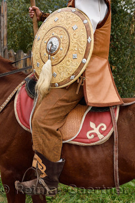Detail of guard in traditional hun clothes with shield and spear on horseback Kazakhstan