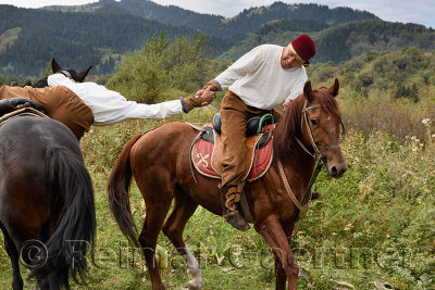 Man pulling rider off horse in Atpen Audaraspak arm wrestling competition Huns village Kazakhstan