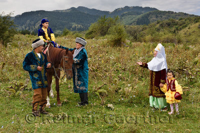 Boy on horse for Sundet Toi circumcision custom with family in traditional Kazakh clothes