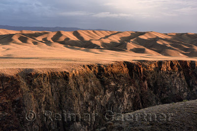 Sunset on rolling hills of Black Canyon on the Charyn river with Tien Shen mountains Kazakhstan