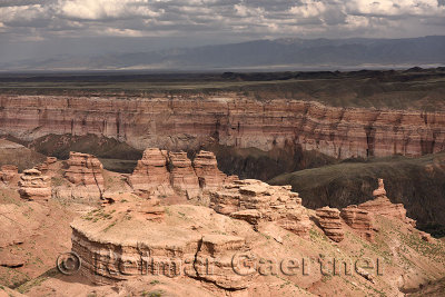 Hoodoos of Charyn Canyon National Park in sun with distant Tien Shen mountains Kazakhstan