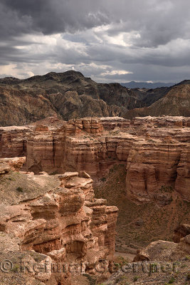 Dark clouds over red sedimentary layers at Charyn Canyon National Park Kazakhstan