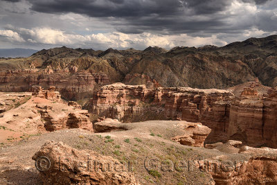 Dark clouds over Charyn Canyon at sundown with Tien Shen mountains Kazakhstan