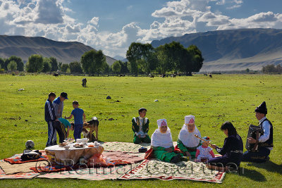Picnic with family in traditional clothes singing in Saty pastureland on the Chilik river Kazakhstan