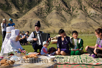 Saty townsfolk some in traditional clothes at a picnic by the Chilik river Kungey Aaltau mountains Kazakhstan