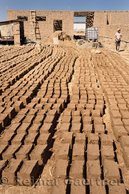 Mud bricks layed out in the sun to dry at home construction site near ...