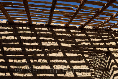 Shadow pattern of timber beams and slats on mud brick walls of unfinished house near Shymkent Kazakhstan