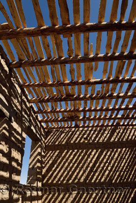Striped shadows of wood ceiling beams and slats on mud brick walls of new house near Shymkent Kazakhstan