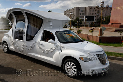 Elaborate limousine made to look like a carriage for a wedding party at Ordabassy square fountain Shymkent Kazakhstan