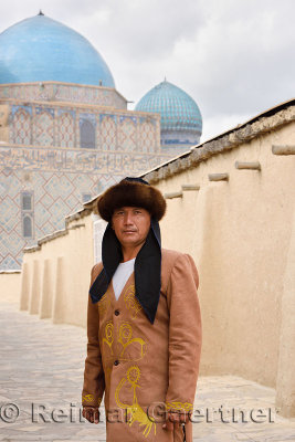 Man in traditional Kazakh clothes standing at Khoja Ahmed Yasawi mausoleum Turkestan Kazakhstan