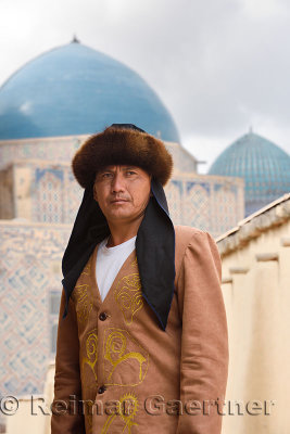 close up of man in traditional Kazakh clothes standing at Khoja Ahmed Yasawi mausoleum Turkestan Kazakhstan
