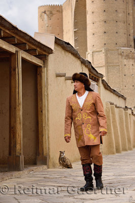 Bird handler in traditional clothes walking at Khoja Ahmed Yasawi mausoleum Turkestan Kazakhstan