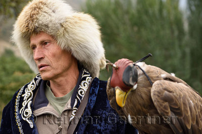 Eagle hunter in traditional clothes with hooded White Tailed Eagle Sunkar sanctuary Almaty Kazakhstan
