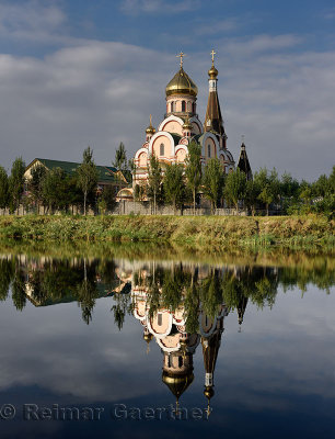 Orthodox Church of Exaltation of the Holy Cross in Almaty Kazakhstan reflected in lake water