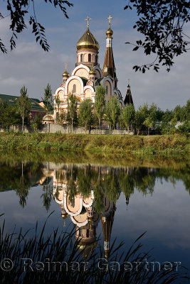 Orthodox Church of Exaltation of the Holy Cross in Almaty Kazakhstan reflected in pond water