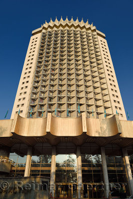 Front doors of the gold Hotel Kazakhstan landmark in Almaty with blue sky