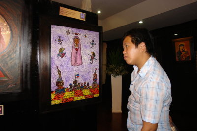 Artist Lawton Ladao studies a Don de Dios painting