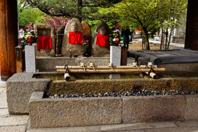Statues over dippers and a water basin, at Sanjusangen-do Temple