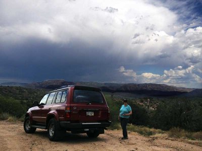 Judy with storm clouds and Land Cruiser