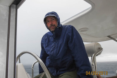 The Captain, sailing in the rain, while the crew looks on...from the cabin