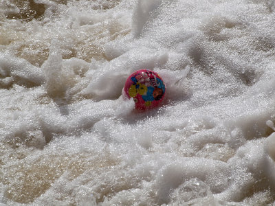 Pink ball in foaming water at the bottom of the dam