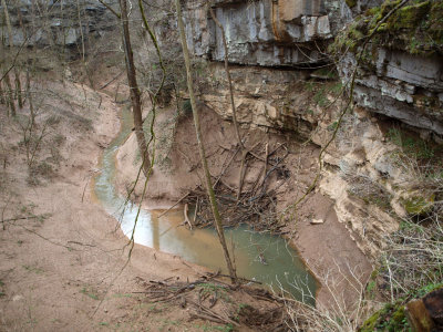 The stream disappears under the rocks