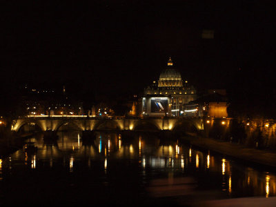 Dome of St. Peter's Basilica over the Tiber river at night
