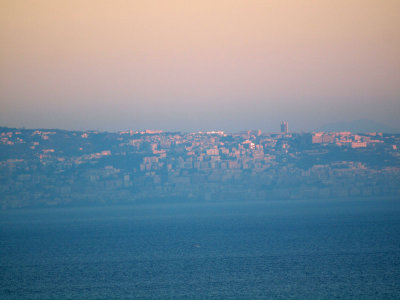 First rays hit the buildings across the bay from Sorrento