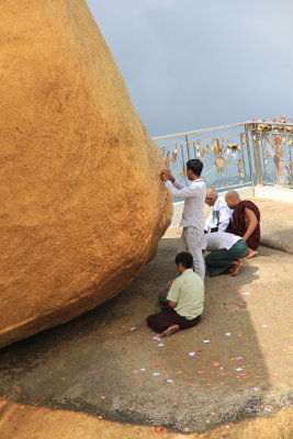 Attaching gold leaf to the rock