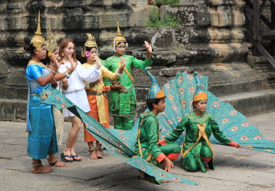 Apsara dancers posing with tourists at Angkor Wat