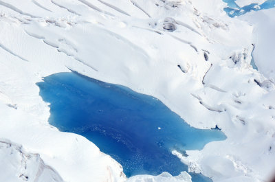 A bright blue pool of glacial melt on Ruth Glacier